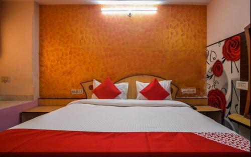 una camera da letto con un grande letto con cuscini rossi di Pax in hotel a Udaipur
