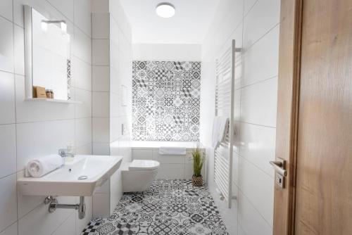 La salle de bains blanche est pourvue d'un lavabo et de toilettes. dans l'établissement Residence Morris Mladá Boleslav, à Mladá Boleslav