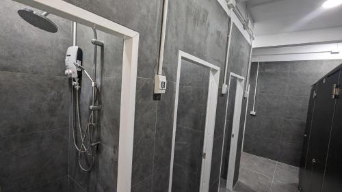 a bathroom with a shower with a glass door at Urban Jungle Hostel in Bangkok