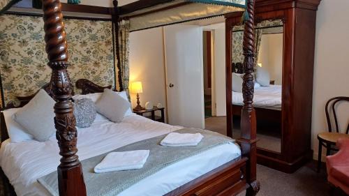 a bedroom with a four poster bed and a mirror at Ardbrecknish House in Dalmally