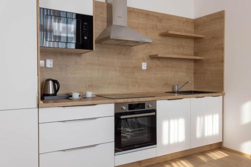 a kitchen with white cabinets and a stove at Residence Morris Mladá Boleslav in Mladá Boleslav