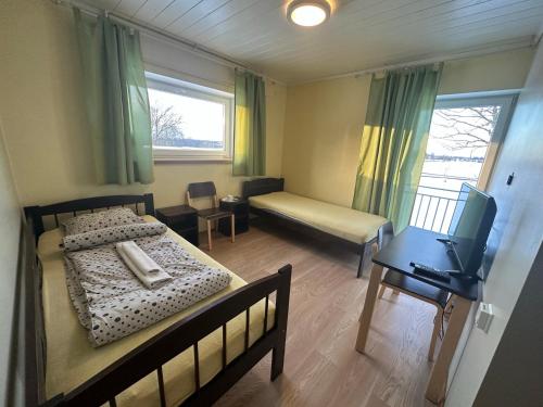 1 dormitorio con cama, escritorio y ventana en Tristvere maja, en Kadrina