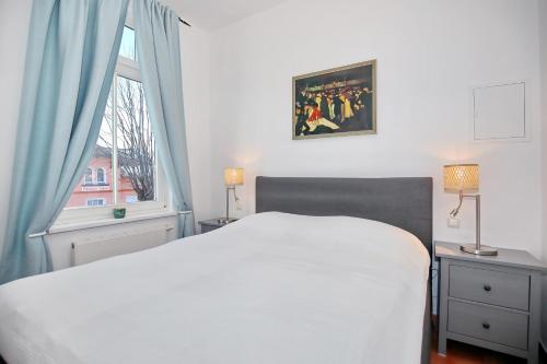sypialnia z białym łóżkiem i oknem w obiekcie Strandstraße 16 Wohnung 09 w mieście Kühlungsborn