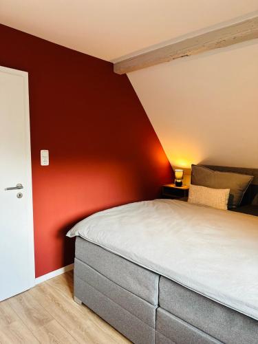 Un dormitorio con una pared roja y una cama en Herzogin, 