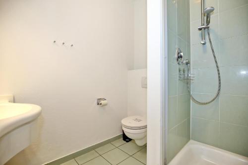 een badkamer met een toilet en een glazen douche bij Strandstraße 16 Wohnung 09 in Kühlungsborn