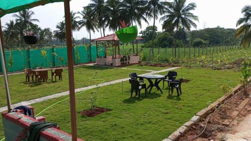 a patio with chairs and a table in a yard at freedome at homestay in Chāmundi