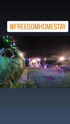 a night view of a party with lights and a sign at freedome at homestay in Chāmundi