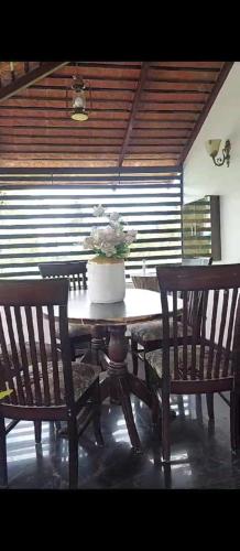 a table with two chairs and a pot of flowers on it at freedome at homestay in Chāmundi