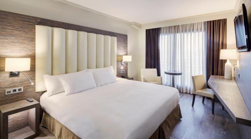 Gran Hotel Luna de Granada في غرناطة: سرير أبيض كبير في غرفة الفندق