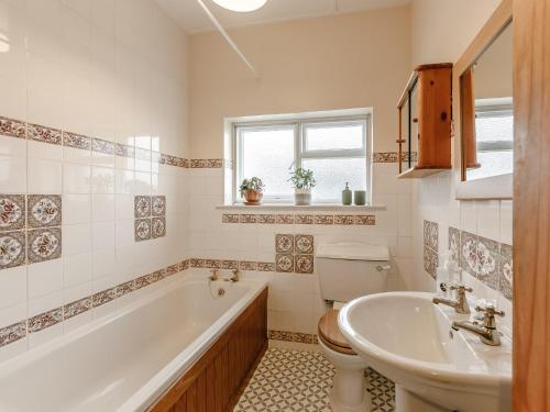 a bathroom with a tub and a toilet and a sink at 4 Bed in Wylam 90433 in Wylam