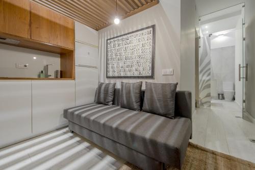 un sofá en una sala de estar con una foto en la pared en Apt con estilo - 5pax en zona Tirso-Centro, en Madrid