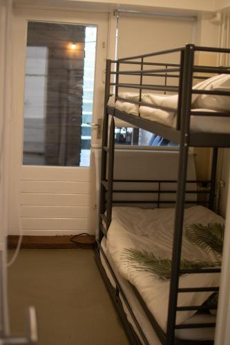 two bunk beds in a room with a window at Souterrain aan zee in Noordwijk