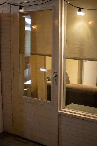 Una puerta blanca con una ventana en una habitación en Souterrain aan zee en Noordwijk