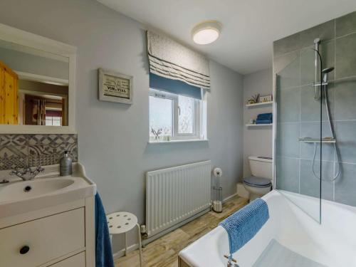 a bathroom with a tub and a sink and a shower at 3 Bed in Bamburgh 90351 in Belford