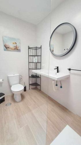a bathroom with a toilet and a sink and a mirror at Costa Gaviotas Bungalow in Puerto del Carmen