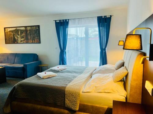 a bedroom with a bed and a couch and a window at Hotel & Restaurant Pod Kaštany in Krupka - Marsov