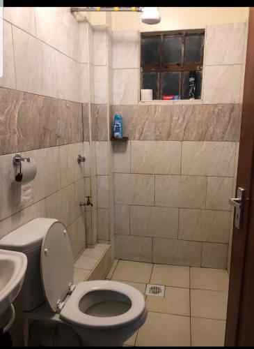 een badkamer met een toilet en een wastafel bij Fancy Gateaway in Ruiru