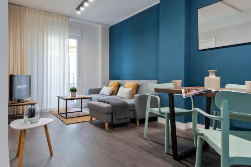 ein Wohnzimmer mit blauen Wänden und einem Sofa in der Unterkunft Espíritu Santo Suite Apartment in Sevilla