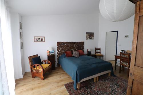 ein Schlafzimmer mit einem Bett mit einer blauen Decke in der Unterkunft CHAMBRES chez l'habitant Córdoba et Lhassa in Bordeaux