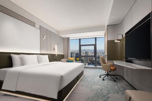 a hotel room with a large bed and a television at Crowne Plaza Jinan Runhua by IHG in Jinan