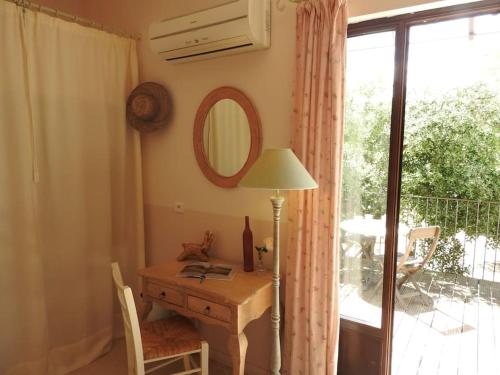 a room with a desk with a mirror and a window at Le Mas de l'Escaillon in Saint-Saturnin-les-Apt