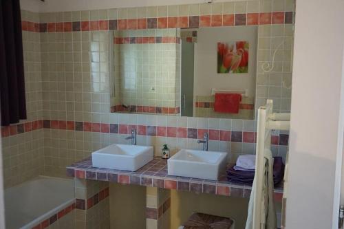 a bathroom with two sinks and a mirror and a tub at Le Mas de l'Escaillon in Saint-Saturnin-les-Apt
