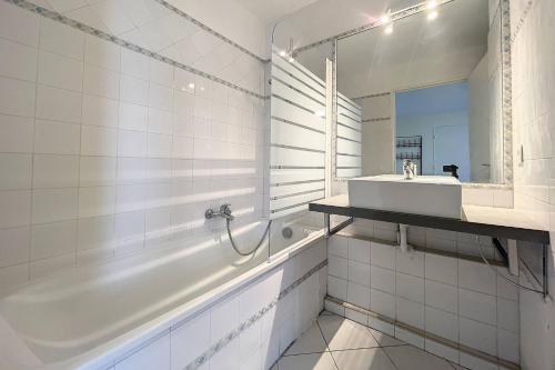 une salle de bain blanche avec une baignoire et un lavabo dans l'établissement Cannes - Studio 5mn Palais, à Cannes