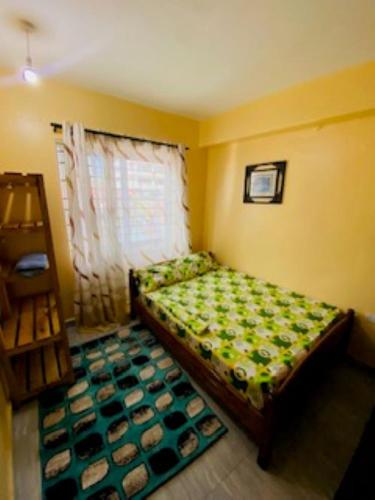 ein kleines Schlafzimmer mit einem Bett in einem Zimmer in der Unterkunft Qarib Rock City in Mwanza