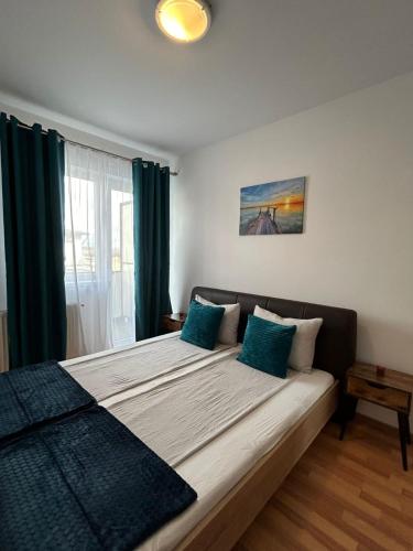 1 dormitorio con 1 cama grande con almohadas azules en Pitters Home Two, en Sibiu
