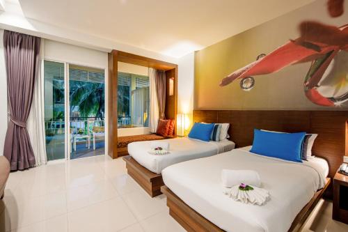 a hotel room with two beds and a window at A2 Pool Resort, Phuket Town - scheduled shuttle to Phuket Old Town in Phuket