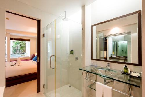 a bathroom with a sink and a mirror and a bed at A2 Pool Resort, Phuket Town - scheduled shuttle to Phuket Old Town in Phuket