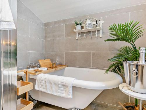 a bathroom with a white tub and a plant at 2 Bed in Hayle 90552 in Phillack