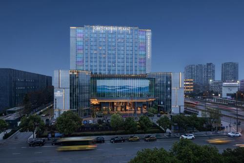 un grand bâtiment en verre avec des voitures dans une ville dans l'établissement Crowne Plaza Chengdu Wuhou, an IHG Hotel, à Chengdu