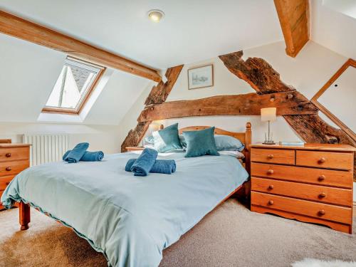 a bedroom with a large bed with blue pillows at 4 Bed in Hay on Wye 90375 in Builth Wells