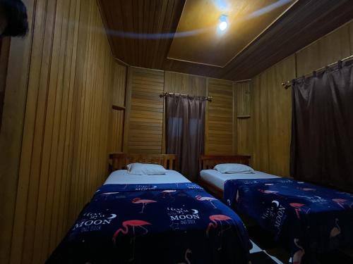 two beds in a small room with a room with at THE SINGKI HOME FAMILY in Rantepao