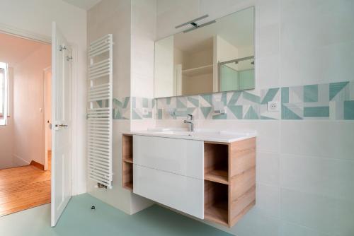 une salle de bain avec un lavabo et un miroir dans l'établissement Ty Boca - Maison pour 6 avec jardin, à Dinéault