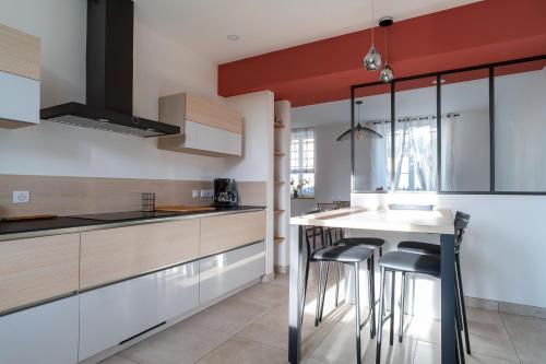 une cuisine avec un comptoir blanc et des tabourets dans l'établissement Ty Boca - Maison pour 6 avec jardin, à Dinéault