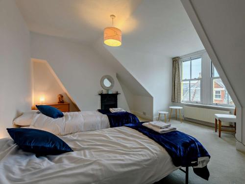 een slaapkamer met 2 bedden en blauwe kussens bij 5 Bed in Swanage 90502 in Swanage