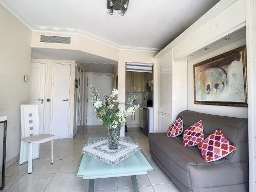 - un salon avec un canapé et un vase de fleurs sur une table dans l'établissement Cannes - 2 pièces quartier Palm Beach, à Cannes