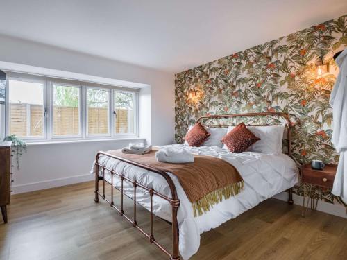 a bedroom with a bed with a floral accent wall at 4 Bed in Burnham-on-Sea 90365 in Badgworth