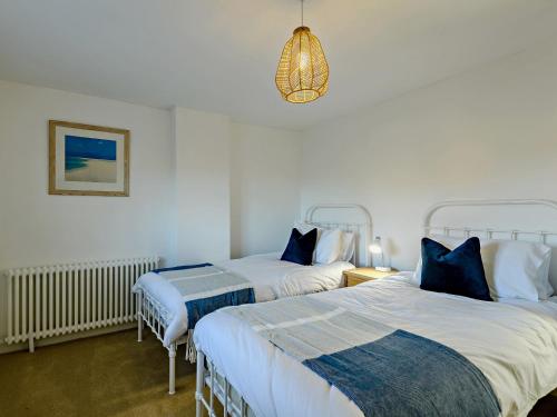a bedroom with two beds and a chandelier at 2 Bed in Great Walsingham 90535 in Little Walsingham