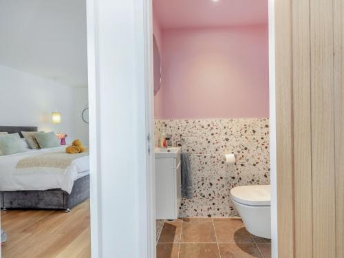 ein Schlafzimmer mit einem Bett und ein Badezimmer mit einem WC in der Unterkunft 3 Bed in Brixham 90614 in Brixham