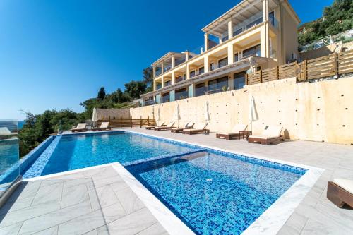 a swimming pool in front of a building at Lido Paradise Apartments Corfu in Agios Gordios