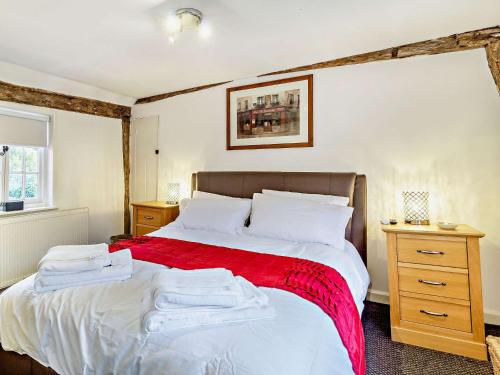 ein Schlafzimmer mit einem Bett mit einer roten Decke in der Unterkunft 2 Bed in Needham Market 90561 in Stowmarket
