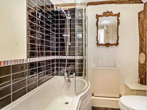 a bathroom with a tub and a toilet and a mirror at 2 Bed in Needham Market 90561 in Stowmarket