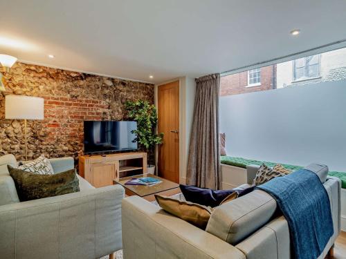 a living room with a couch and a tv at 3 Bed in Fakenham 90681 in Fakenham