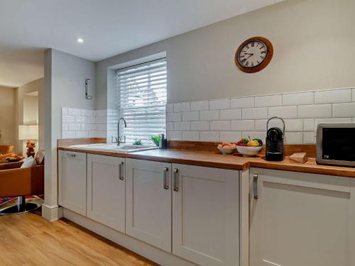 a kitchen with a sink and a clock on the wall at 3 Bed in Fakenham 90681 in Fakenham