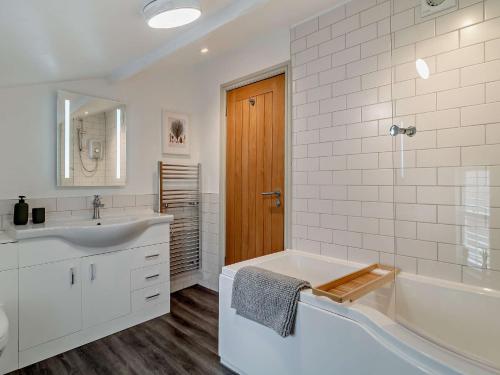 Baño blanco con bañera y lavamanos en 3 Bed in Fakenham 90681 en Fakenham
