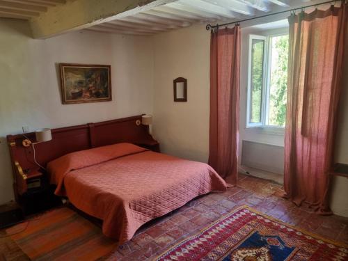 Schlafzimmer mit einem Bett und einem Fenster in der Unterkunft Grand Mas Provençal avec jacuzzi in Sisteron