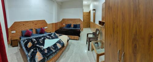 ein Schlafzimmer mit zwei Betten mit blauen Kissen in der Unterkunft NEW SAMY CAFE AND HOMESTAY in Kasol